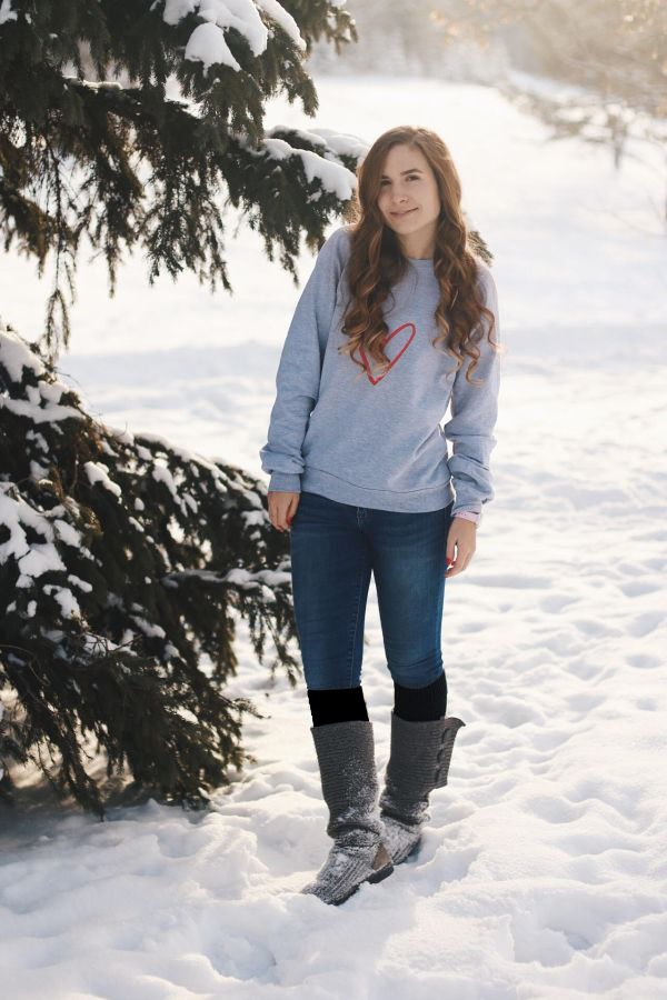 girl wearing blue jeans, black thigh highs, tall dark gray boots, and a light gray sweater with a heart on it