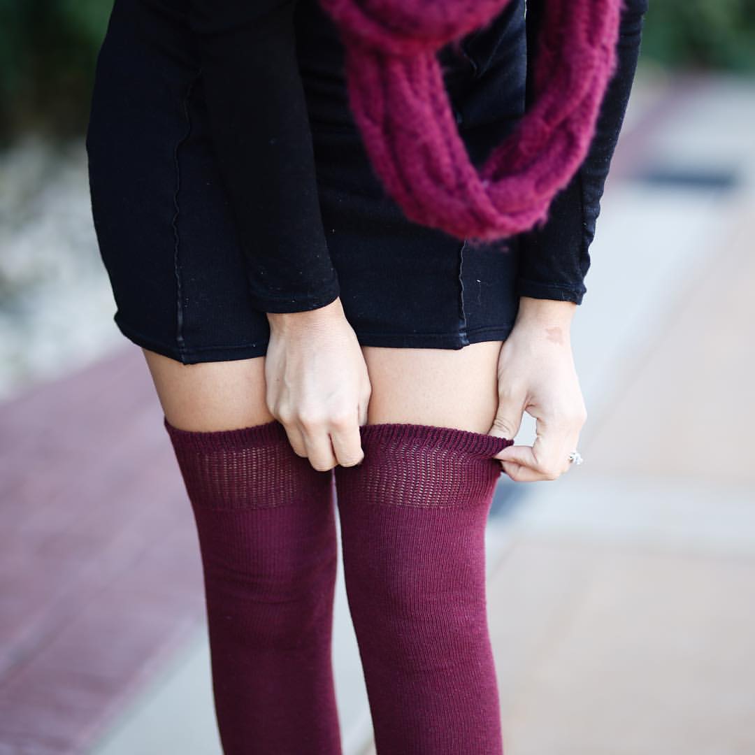 girl pulling up burgundy thigh highs that show no signs of lint